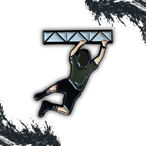 May include: A black and green enamel pin depicting a person hanging from a white metal bar. The person is wearing a green shirt and black shorts.