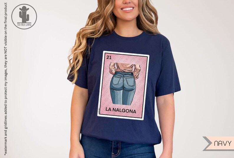 Op de afbeelding: Een marineblauw t-shirt met een roze en witte illustratie van een vrouw in jeans. De illustratie is in de stijl van een traditionele Mexicaanse speelkaart. De tekst "21" en "LA NALGONA" staat op de kaart gedrukt.