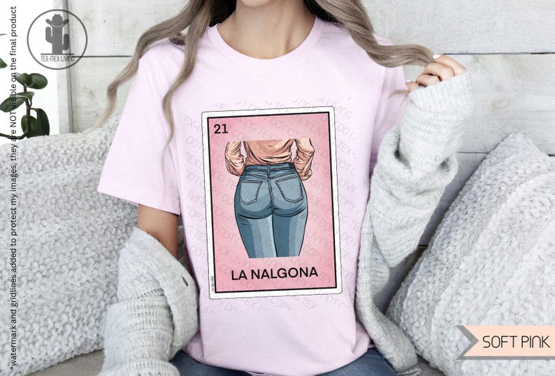 Op de afbeelding: Een roze T-shirt met een afbeelding van een vrouw in blauwe jeans. De afbeelding is een parodie op een traditionele Mexicaanse speelkaart, met het nummer 21 en de tekst "La NalgonA".