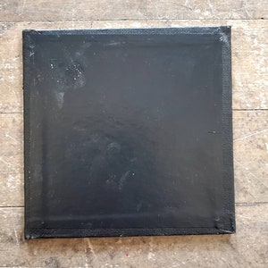 May include: A black canvas with a textured surface. The canvas is stretched and ready for painting.