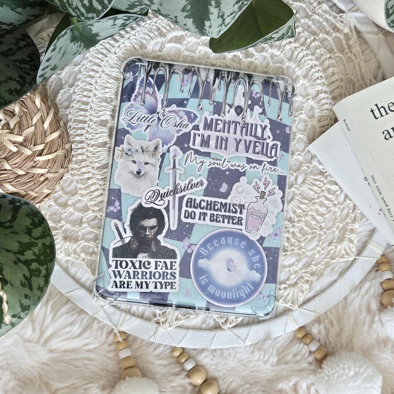 K&ouml;nnte beinhalten: Eine transparente Handyh&uuml;lle mit verschiedenen bunten Aufklebern. Die Aufkleber zeigen einen Wolf, einen Schmetterling, eine Zaubertrankflasche und Text, der "Mentally I'm in Yvelia", "My soul was on fire...", "Quicksilver", "Toxic Fae Warriors Are My Type", "Alchemist Do It Better" und "Because she is moonlight" lautet.