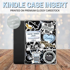 Puede incluir: Un inserto para funda de Kindle en blanco y negro con una variedad de pegatinas coloridas. Las pegatinas presentan referencias a libros y películas de fantasía, incluyendo "In My Fantasy Era", "Fantasy Romance Loading", "Bat Boys Fanatic", "Hello Feyre Darling", "Xaddy", "Dain's Tears", y "Fantasy Readers Book Club".