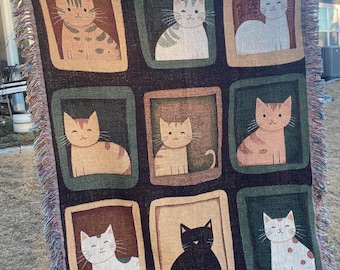 Puede incluir: Un tapiz tejido con nueve imágenes enmarcadas de gatos en varias poses. El tapiz tiene un fondo negro con marcos marrones, verdes y beige. Los gatos están representados en un estilo de dibujos animados con rasgos simples.