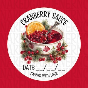 Pode incluir: Um autocolante redondo com fundo vermelho e um círculo branco com uma tigela de molho de cranberry, uma fatia de laranja e uma colher. O texto diz "CRANBERRY SAUCE", "DATE: --/--/--" e "CANNED WITH LOVE".
