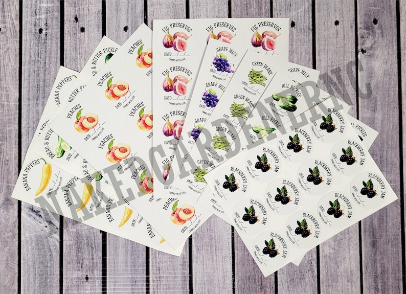 May include: A collection of white labels with various illustrations of fruits, vegetables, and berries. The labels are printed with the names of the items, such as "Peaches", "Fig Preserves", "Green Beans", and "Blackberry Jam".