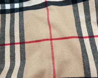 Puede incluir: Tela beige con un patrón de cuadros negros, blancos y rojos.