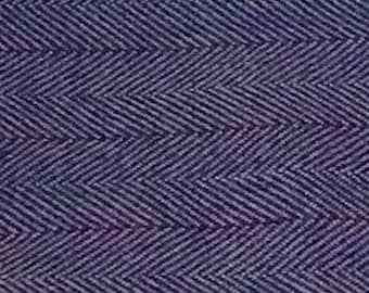 May include: A close-up of a purple and blue fabric with a herringbone pattern.