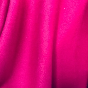 May include: A close-up of a bright pink fabric with a soft, fuzzy texture.
