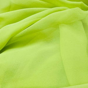 May include: A piece of bright green fabric, folded and draped, showcasing its soft, sheer texture.