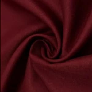 May include: A close-up shot of a deep burgundy fabric, showing soft folds and a swirling pattern. The material appears smooth and luxurious, with a rich, solid colour. The fabric's texture is highlighted by the way it catches the light.