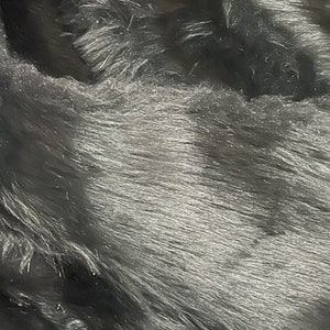 May include: Close-up of a black faux fur fabric with a soft, plush texture.