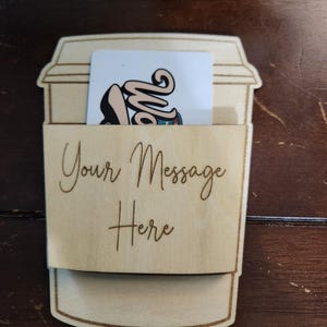 May include: Wooden coffee cup gift card holder with a blank gift card inside and the text "Your Message Here" engraved on the side.