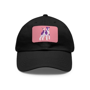 May include: Black baseball cap with a pink patch featuring a cartoon dog with purple and white spots. The dog has a purple head and tail. The patch also includes a butterfly.