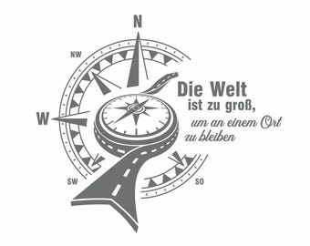 Op de afbeelding: Een kompas met een weg die eromheen slingert, met de tekst "Die Welt ist zu groß, um an einem Ort zu bleiben" in zwarte letters. Het kompas wijst naar het noorden.