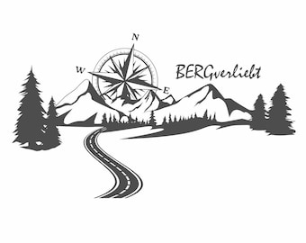 Könnte beinhalten: Ein dunkelgrauer Grafikaufkleber mit einer kurvigen Straße, die auf ein Gebirge zuführt, über dem sich eine Kompassrose befindet. Der Text BERGverliebt ist in einer stilisierten Schrift rechts neben dem Kompass und den Bergen abgebildet.
