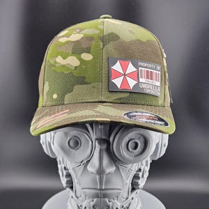 May include: A set of three ceramic mugs with a speckled, cream-colored glaze. Each mug features a different hand-painted floral design in shades of blue, green, and yellow. The mugs have a simple, rounded shape and a comfortable handle.