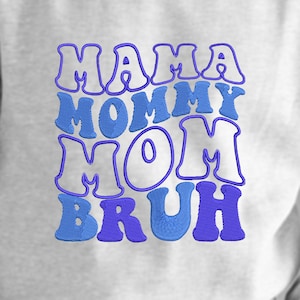 May include: A white t-shirt with blue embroidered text that reads "Mama Mommy Mom  Bruh".