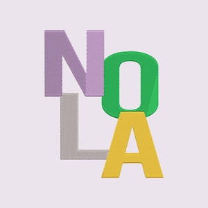 May include: Embroidered design featuring the word "NOLA" in stacked, colorful letters. The "N" is lavender, the "O" is green, the "L" is gray, and the "A" is yellow. The letters have a textured, stitched appearance against a light purple background.