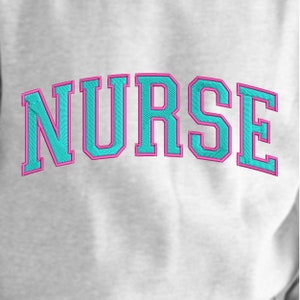 May include: A white sweatshirt with the word "NURSE" embroidered in turquoise blue with a pink outline.