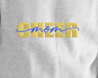 May include: A white sweatshirt with gold embroidered text that says "Cheer mom" in a cursive font with a blue underline.