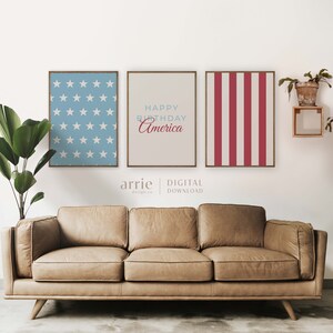 Pode incluir: Tr&ecirc;s impress&otilde;es digitais para uma decora&ccedil;&atilde;o de parede. As impress&otilde;es s&atilde;o de estilo moderno com um esquema de cores vermelho, branco e azul. A impress&atilde;o da esquerda apresenta um fundo azul com estrelas brancas. A impress&atilde;o do centro tem um fundo bege com o texto "Happy Birthday America" em azul e vermelho. A impress&atilde;o da direita tem um padr&atilde;o de listras vermelhas e brancas.