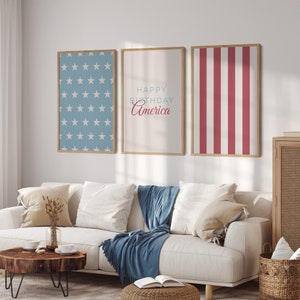 Pode incluir: Tr&ecirc;s impress&otilde;es emolduradas com um tema patri&oacute;tico. A impress&atilde;o da esquerda apresenta um fundo azul com estrelas brancas. A impress&atilde;o do centro tem o texto "Happy Birthday America" em vermelho e azul. A impress&atilde;o da direita tem listras vermelhas e brancas.