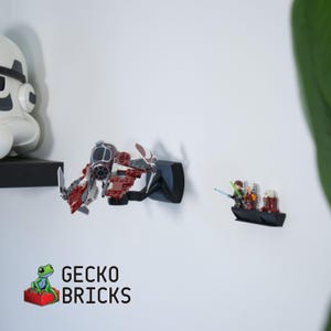May include: A display featuring a red, white, and grey Lego starfighter model mounted on a black bracket. A small Lego boat with figures is also displayed. The text "GECKO BRICKS" is visible below.