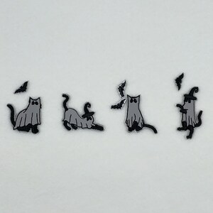 May include: Four black and white cat ghost illustrations with bats. The cats are wearing witch hats and are in different poses.