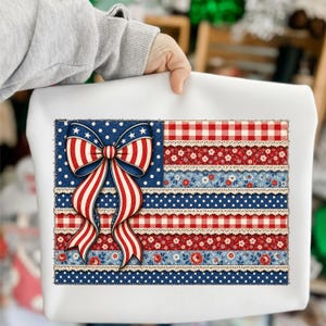 Peut inclure: Un sac fourre-tout blanc avec un motif patriotique. Le motif ressemble au drapeau américain, avec une section bleue à pois et un nœud rouge, blanc et bleu. Le motif du drapeau comprend des rayures rouges et blanches, des motifs floraux et de la dentelle.