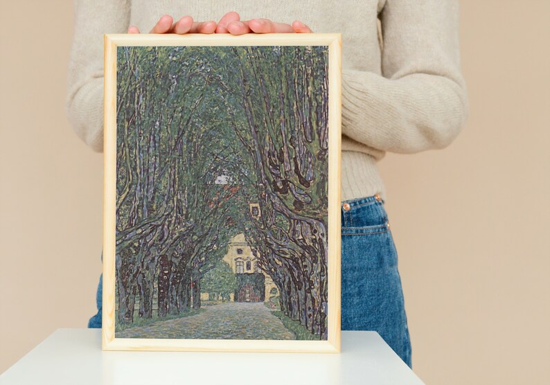 May include: A framed painting of a tree-lined path leading to a building. The trees are green and the path is gray. The building is white with a brown roof.