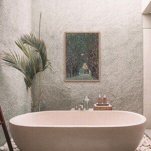 May include: A white bathtub with a wooden ladder and a framed painting of a green tree-lined path leading to a yellow house.