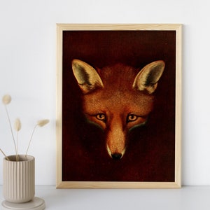 May include: A framed art print featuring a detailed portrait of a fox's face. The fox has reddish-brown fur, with a lighter muzzle and ears. The background is a dark, rich brown, creating a striking contrast. The frame is made of light-colored wood.