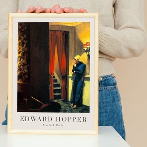 May include: A framed print of a painting by Edward Hopper titled "New York Movie". The painting depicts a woman in a blue dress standing in a dimly lit hallway with red curtains and a staircase.