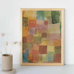 May include: A framed abstract watercolor painting with a geometric pattern of squares and rectangles in shades of brown, yellow, green, and pink.