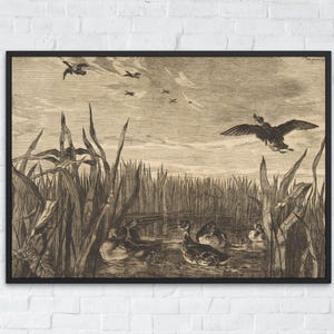 May include: Framed sepia-toned print depicting ducks in a marsh. Several ducks are in the water, while others fly overhead. Tall reeds and grasses fill the foreground, with a cloudy sky in the background. The artwork is in a black frame.