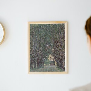 May include: A framed print of a painting depicting a tree-lined path leading to a building. The trees are painted in a pointillist style, with small dots of color creating the image.