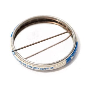 May include: A white ceramic mug with a black handle and the text "But First, Coffee" in a bold, black font. The mug is set against a blurred background, suggesting a cosy setting.