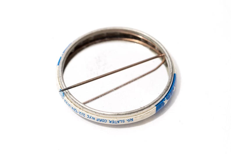 May include: A white ceramic mug with a black handle and the text "But First, Coffee" in a bold, black font. The mug is set against a blurred background, suggesting a cosy setting.