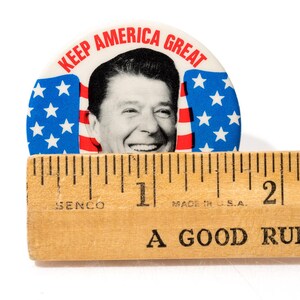 May include: A white ceramic mug with a black handle and the text "But First, Coffee" in a black, handwritten-style font. The mug is on a white surface.