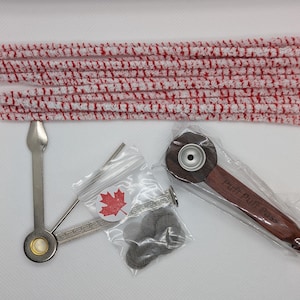 May include: A smoking pipe kit with a wooden pipe, a metal pipe tool, a pack of pipe cleaners, and a pack of pipe screens. The pipe is engraved with the words "Puff Puff Pass".