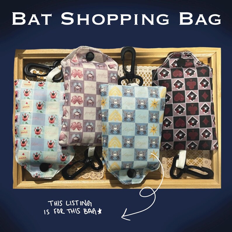 Puede incluir: Cuatro bolsas de compras con estampado de murci&eacute;lagos en una bandeja de madera. Las bolsas presentan varios dise&ntilde;os, incluyendo palos de cartas, lazos e ilustraciones de murci&eacute;lagos. Cada bolsa tiene un asa negra y un cierre a presi&oacute;n. El texto "BAT SHOPPING BAG" est&aacute; en la parte superior.