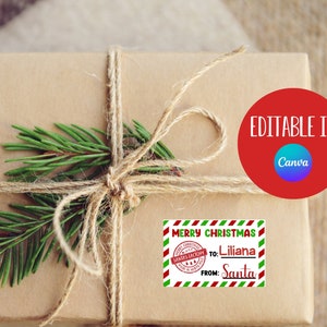 May include: A brown paper gift box tied with twine and decorated with a green pine sprig. A red and green striped label with the text "Merry Christmas" and a red stamp with the text "Santa's Workshop" is attached to the box. The label also includes the text "To: Liliana From: Santa". The text "Editable in Canva" is written in white on a red circle.