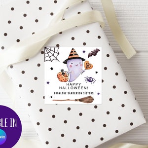 May include: A white gift tag with black polka dots featuring a cartoon ghost wearing a witch hat and holding a candy bucket. The text reads "Happy Halloween! From: The Sanderson Sisters".