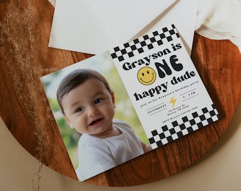 May include: A birthday party invitation with a black and white checkered background. The invitation says "Grayson is ONE happy dude" with a smiley face and a lightning bolt. The invitation also includes the date, time, and location of the party.