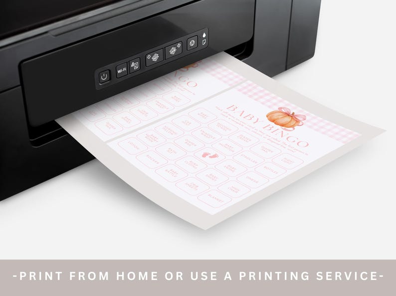 May include: A black printer printing a baby bingo game sheet. The sheet has a pink and white gingham border and features a pumpkin graphic. The text "BABY BINGO" is visible, along with other text in pink boxes. The bottom of the image reads "-PRINT FROM HOME OR USE A PRINTING SERVICE-".