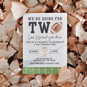 May include: A white card with a football theme for a child's second birthday party. The card says "We're going for two!" and "Liam's second year down." It includes the date "October 24" and time "@2PM".
