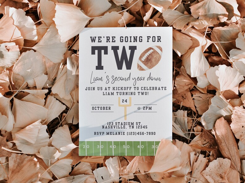 May include: A white card with a football theme for a child's second birthday party. The card says "We're going for two!" and "Liam's second year down." It includes the date "October 24" and time "@2PM".