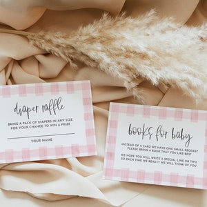 May include: Two pink and white gingham patterned cards with black text. The top card says "diaper raffle" and asks guests to bring a pack of diapers for a chance to win a prize. The bottom card says "books for baby" and asks guests to bring a book for the baby.