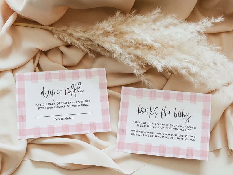 May include: Two pink and white gingham patterned cards with black text. The top card says "diaper raffle" and asks guests to bring a pack of diapers for a chance to win a prize. The bottom card says "books for baby" and asks guests to bring a book for the baby.