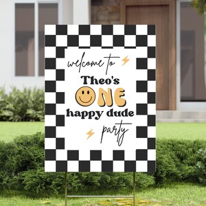 Puede incluir: Un cartel a cuadros blanco y negro con el texto "welcome to Theo's ONE happy dude party" en amarillo y negro. Una cara sonriente est&aacute; en el centro del cartel.